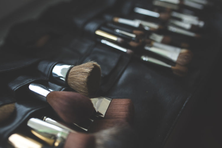 A stylish arrangement of makeup brushes set against a dark, elegant background.