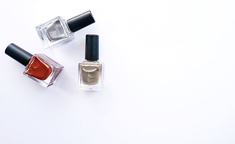 Three nail polish bottles arranged elegantly against a white background.